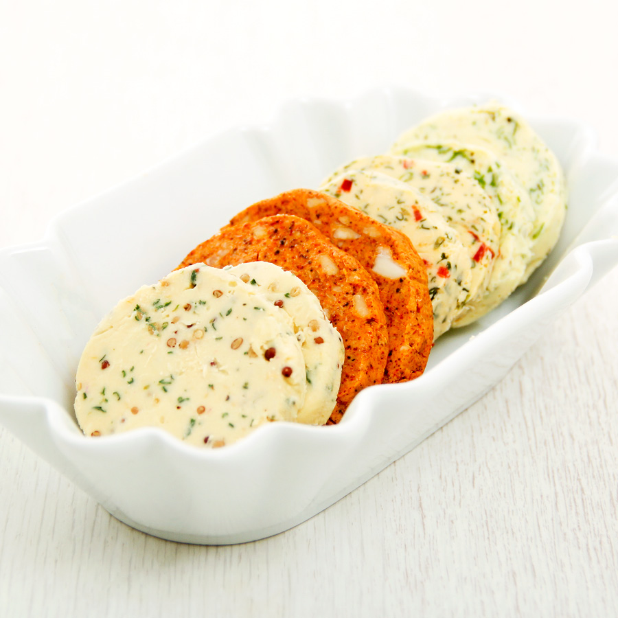 Savoury flavoured butters in a white dish