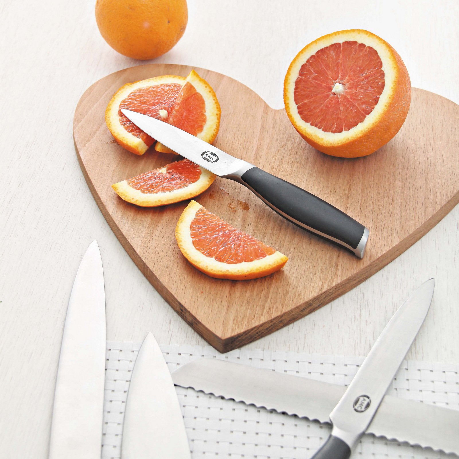 AMC Edge knives on cutting board with sliced orange.